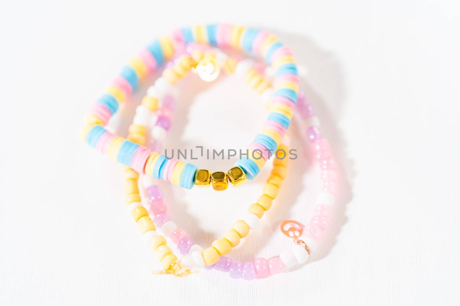Little girl's charming bracelets adorned with clay and sea beads.