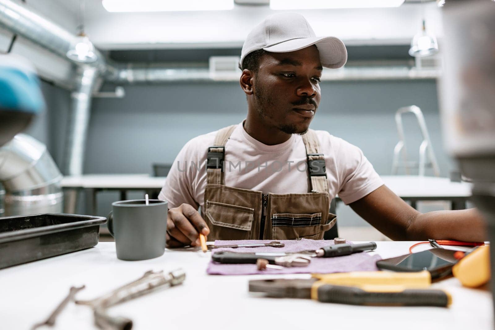 A focused individual organizes various tools on a table in a contemporary workshop.
