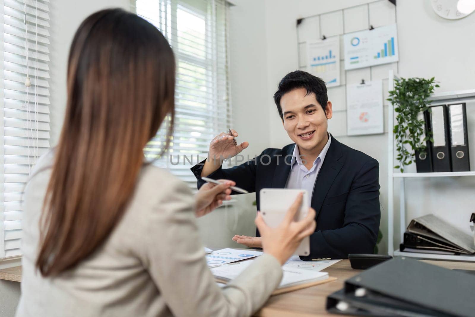 A man and woman in a professional setting discussing financial strategies, emphasizing collaboration and teamwork.