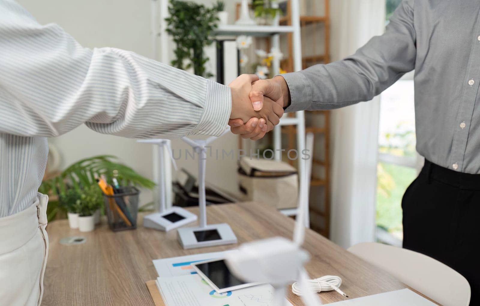A close-up view of two colleagues shaking hands, emphasizing their partnership and commitment to ESG values in business.