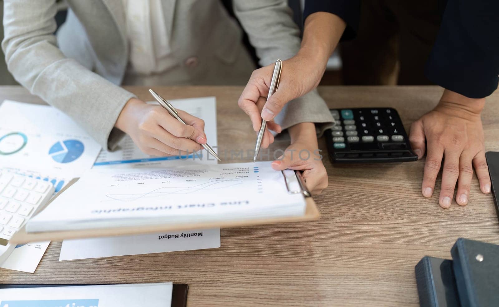 Two business professionals engaged in a detailed review of financial documents, collaborating on strategies in a modern office.