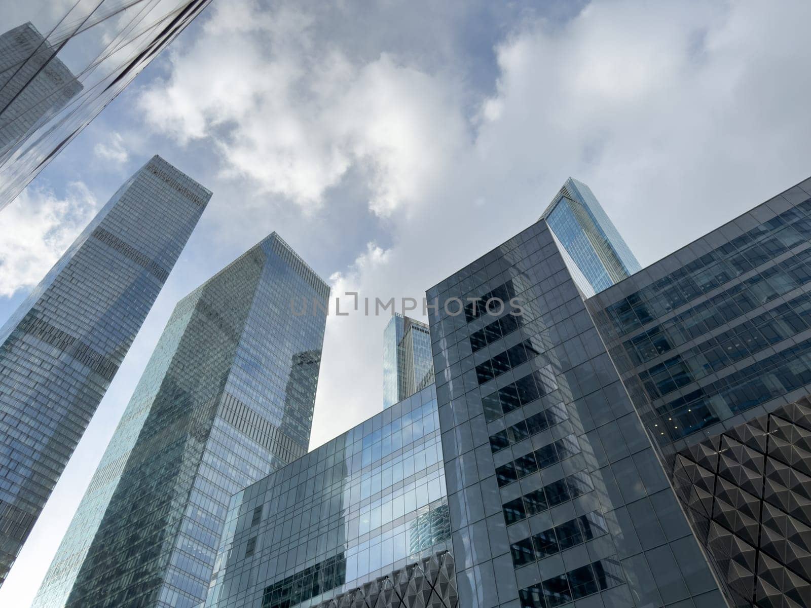 Modern glass skyscrapers reflecting the cloudy sky in Moscow City business district, showcasing contemporary architecture and the growing influence of global urban development