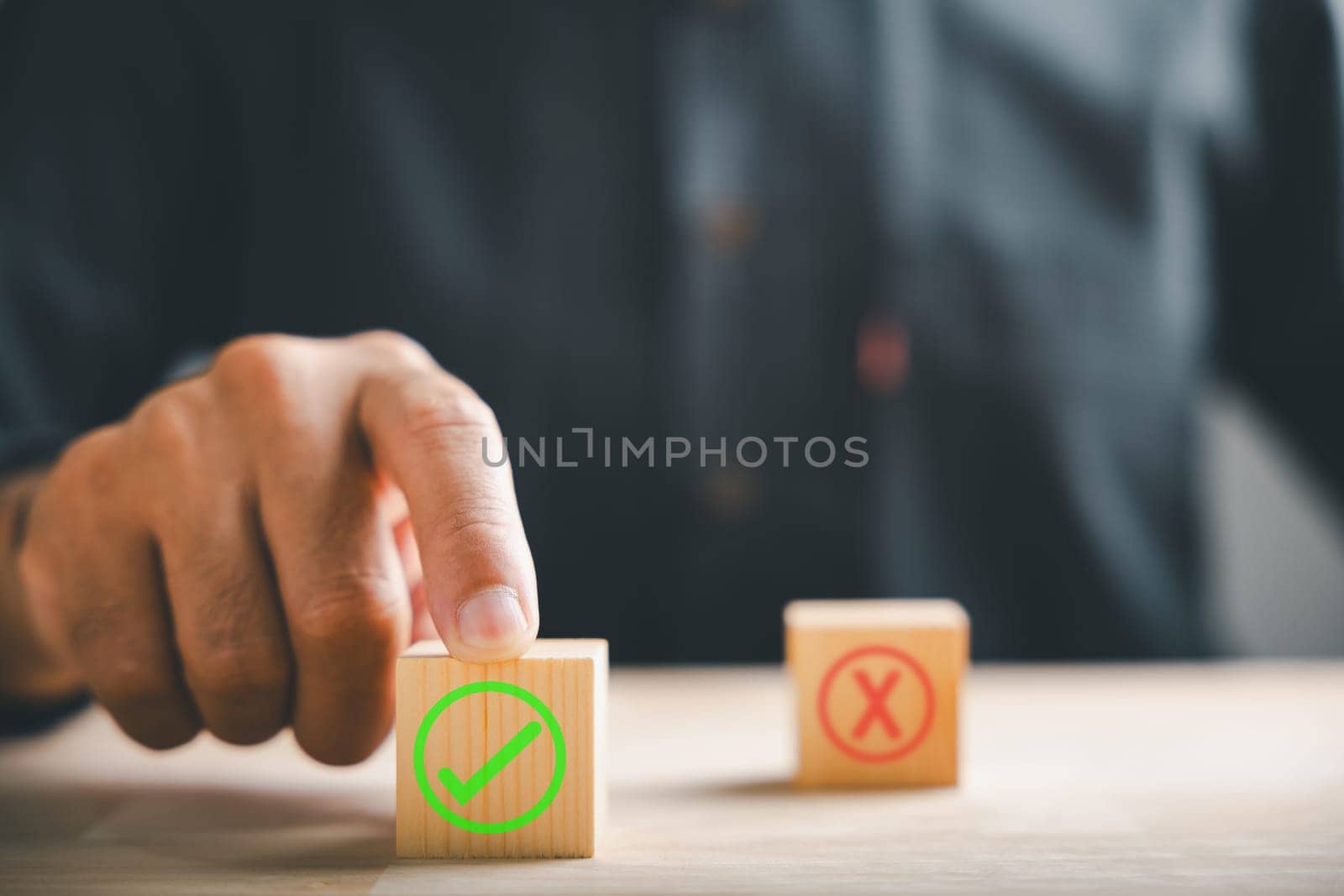 Finger of businessman touches wooden cubes with check marks showing right and wrong choices. Communicates choice validation in decision-making. Think With Yes Or No Choice.