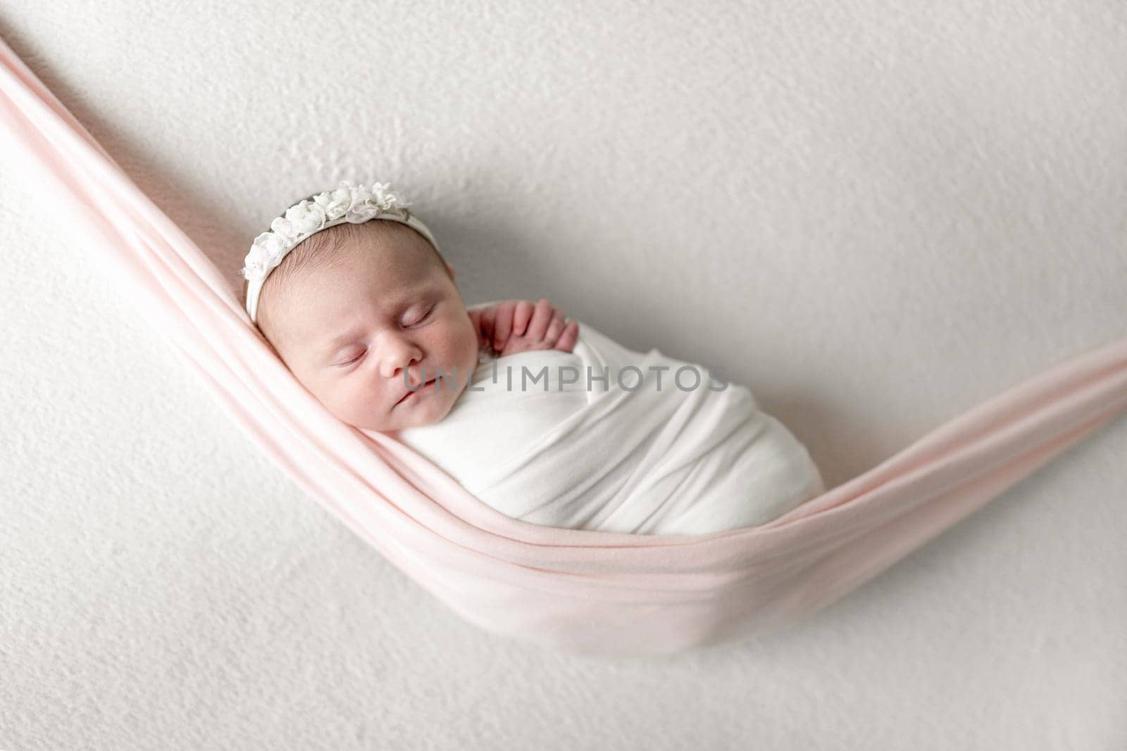 Studio Photo Session Of A Newborn Baby Girl Sleeping In A Hammock