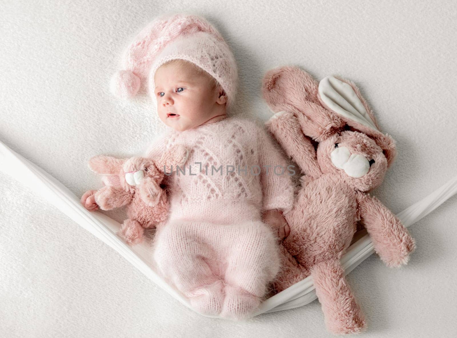 Studio Photoshoot Of A Newborn Baby Girl On A Swing With A Toy Bunny