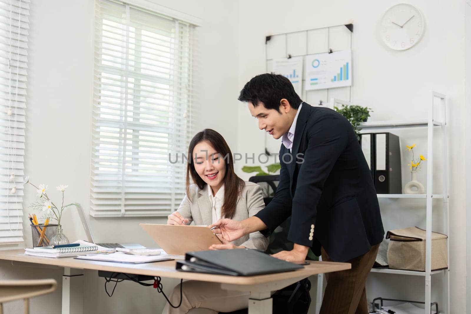 A financial consultant and client review documents and discuss strategies, highlighting the importance of financial planning and collaboration.