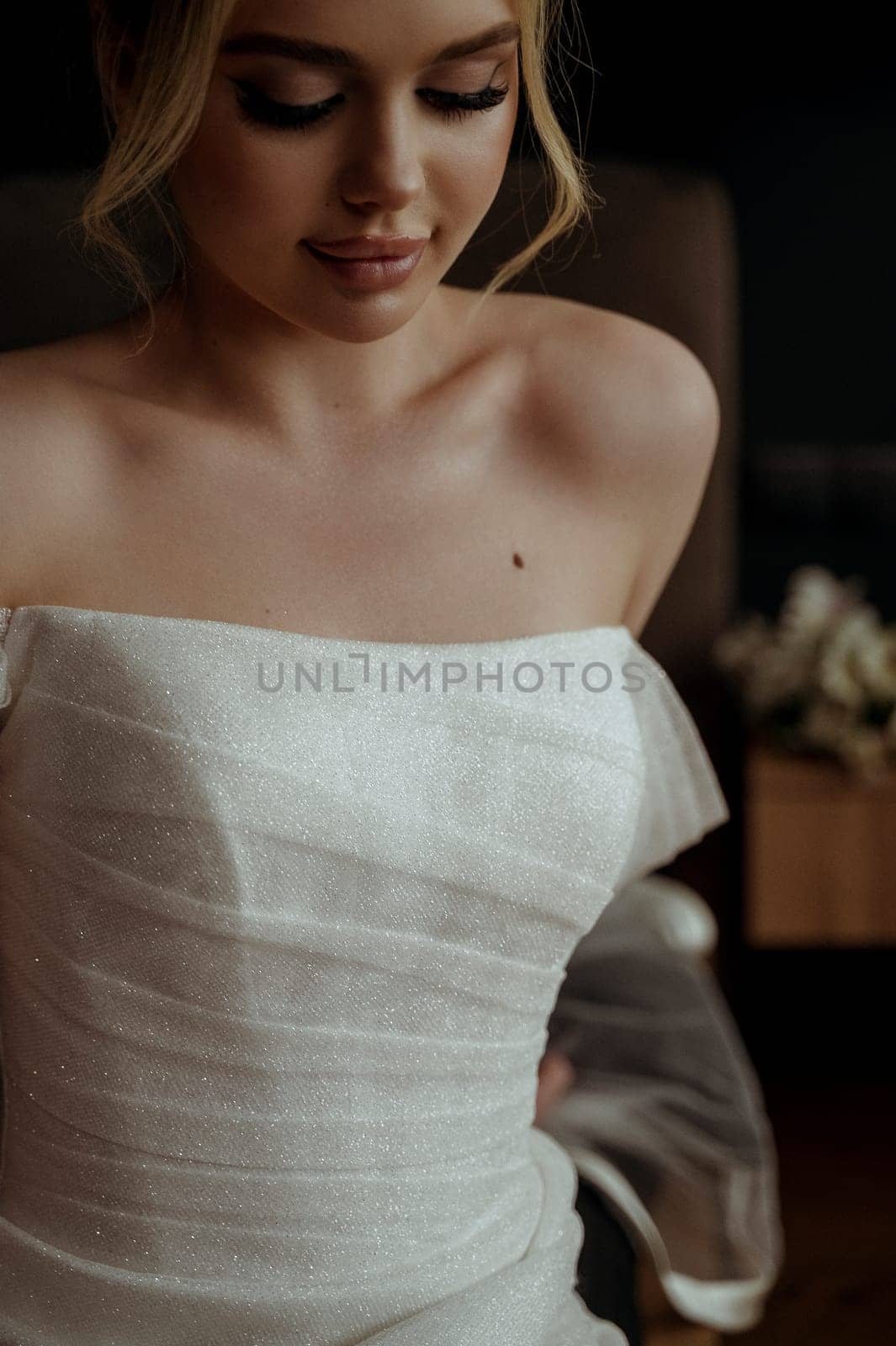Close-up of bride's skin and shoulders. Beautiful bride Fashion portrait in wedding luxury dress with lace and crystals in dark interior.