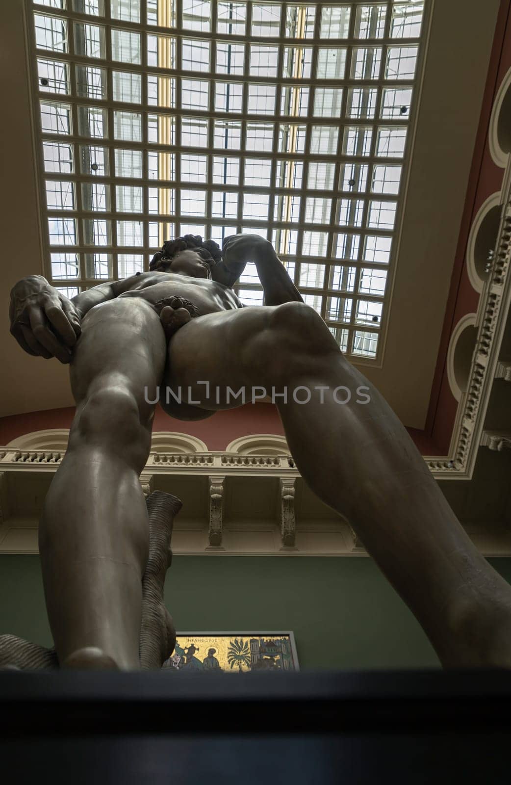 London, UK - May 07, 2025 - Looking up of A magnificent plaster cast of Michelangelo's David sculpture, uses metal rods to support the structure to mount the left and right arms to the torso Displayed in The V&A (Victoria and Albert Museum) in London. use it as your Wallpaper, Poster and Space for text, Selective focus.