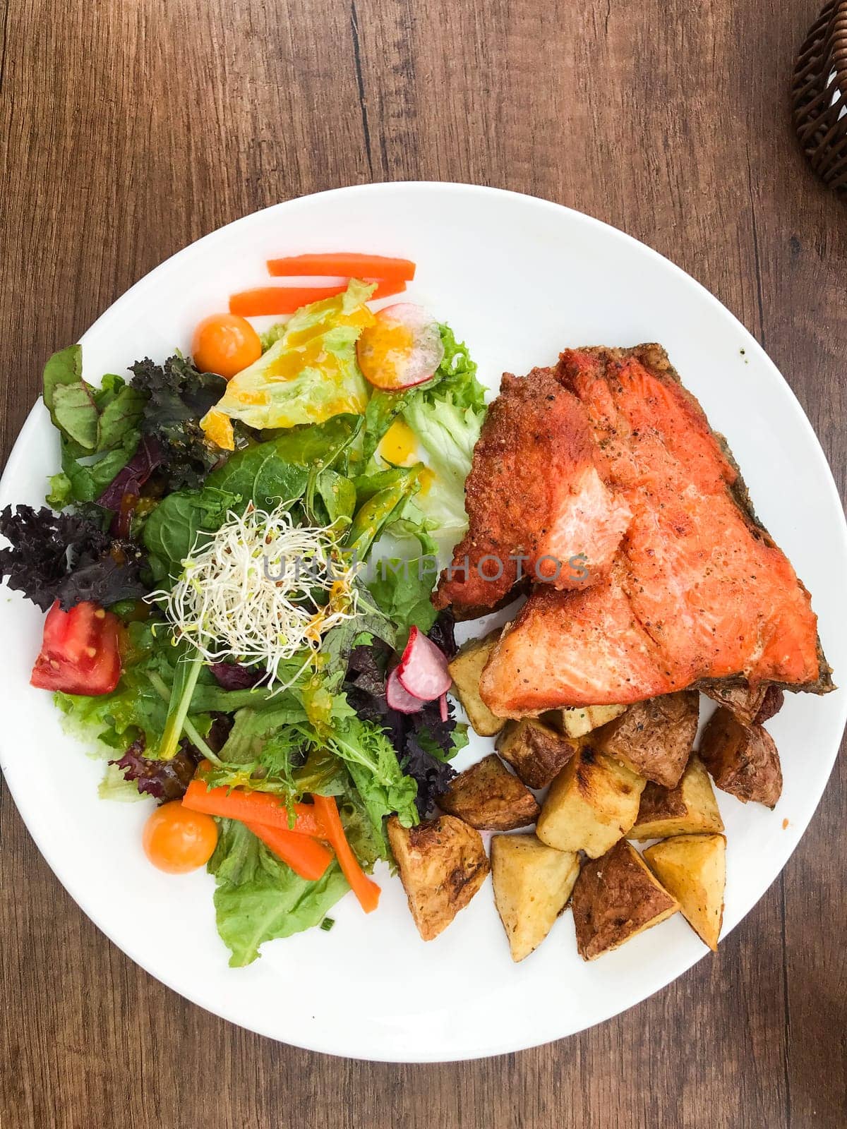 Delicious and healthy meal featuring grilled salmon, roasted potatoes, and a vibrant salad, served in a cusco restaurant
