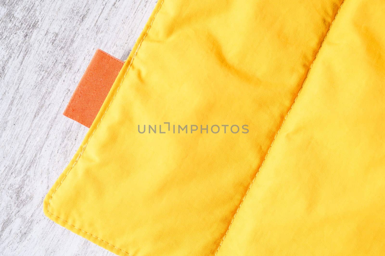 Close up of yellow pet friendly waterproof and windproof breathable fabric with orange label, ideal for outdoor activities