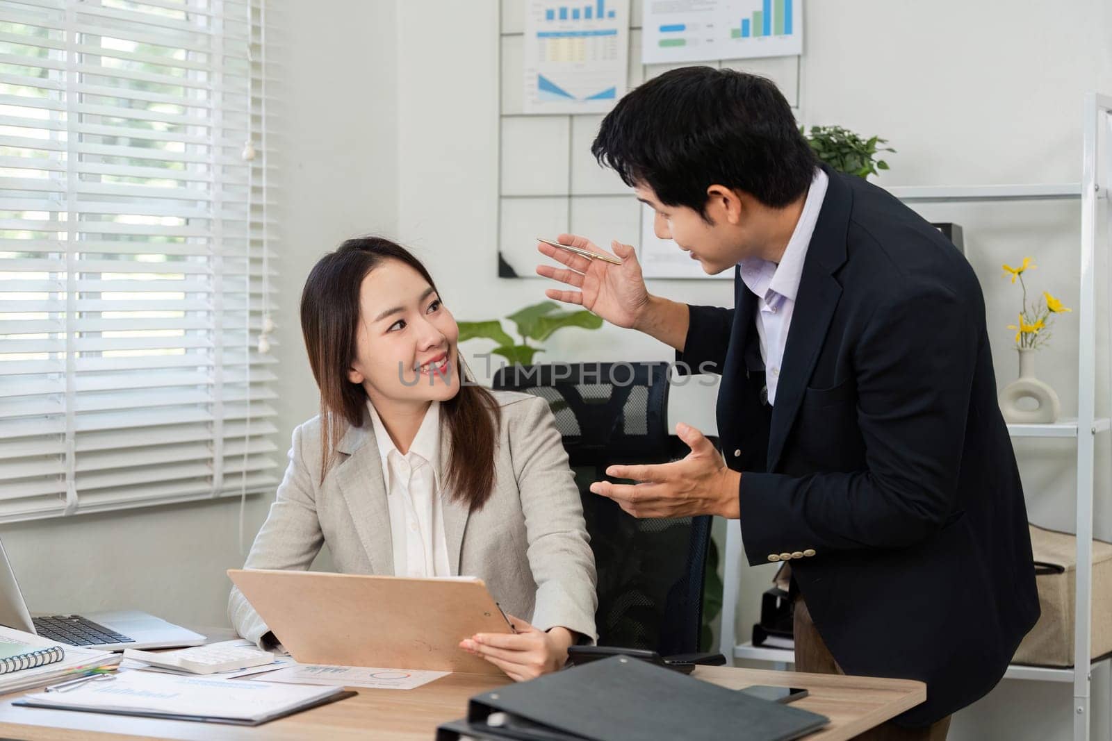 A businessman and businesswoman engage in a lively discussion about financial strategies, highlighting collaboration and professionalism.