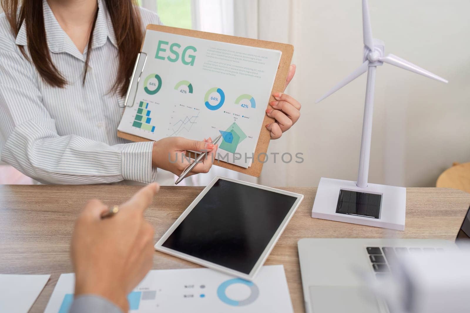 A business meeting focused on ESG data analysis and renewable energy models, showcasing innovative strategies for sustainability.