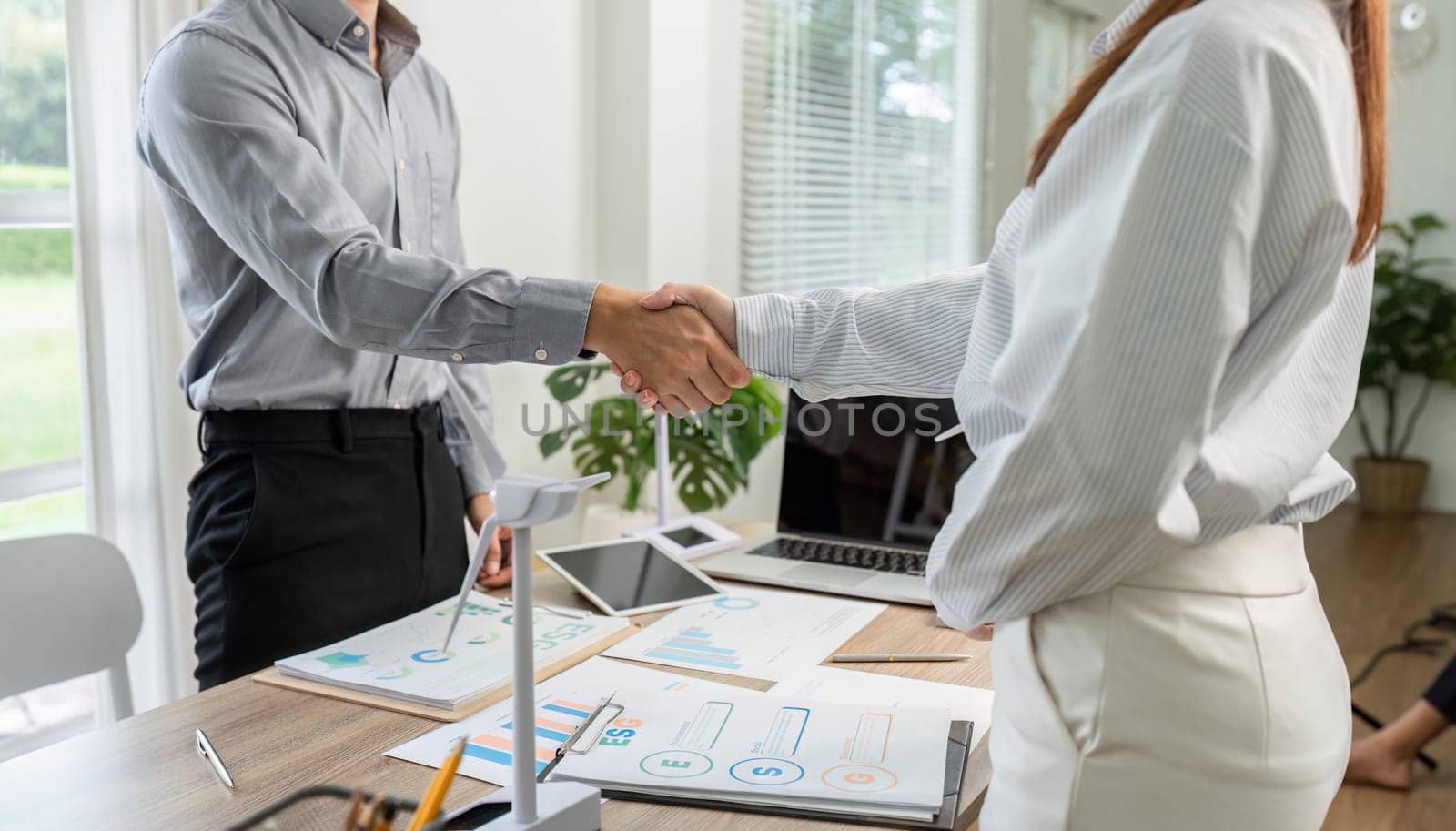 A business handshake symbolizing the conclusion of an ESG-focused deal, highlighting corporate responsibility and collaboration.