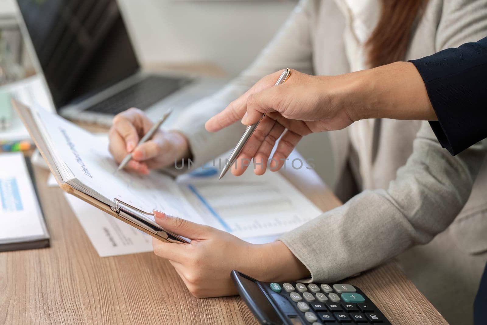 Close-up of hands reviewing financial documents during a collaborative planning session, emphasizing teamwork and strategy.