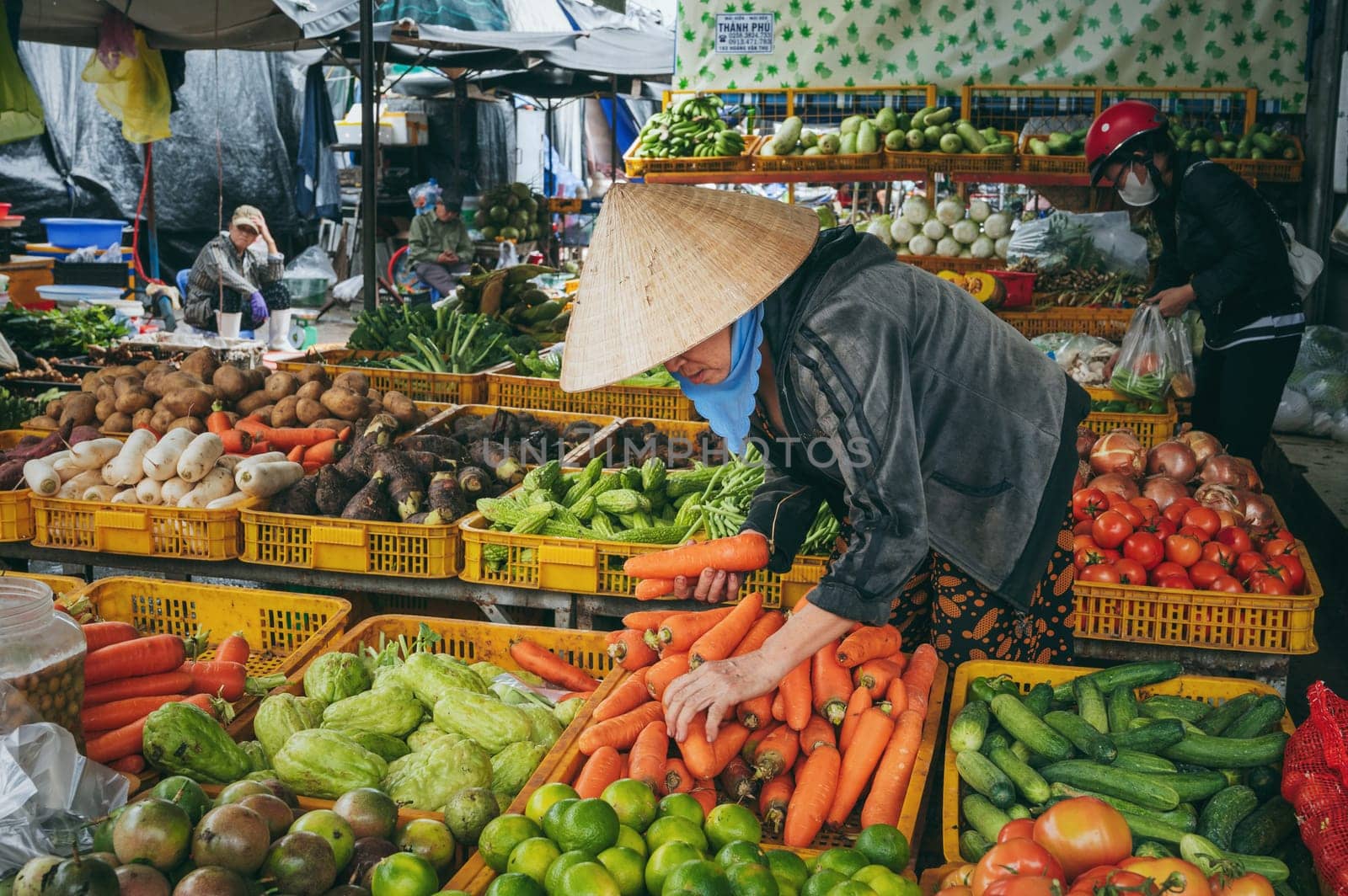 A Vietnamese woman buys fresh vegetables at a local Nha Trang market, Vietnam - December 16, 2024