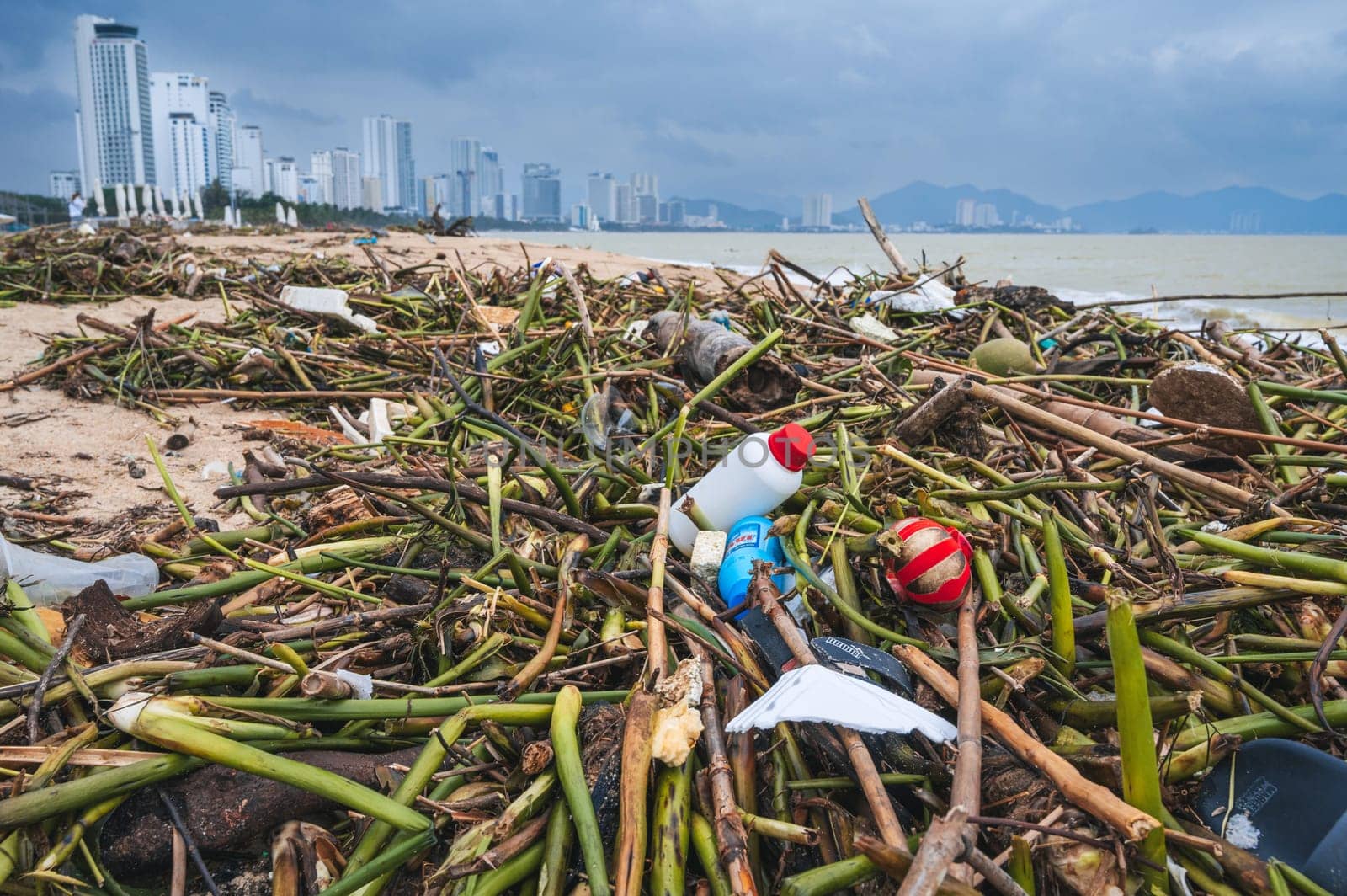 A pile of vegetable and plastic debris lies on the seashore after a storm in Asia. Nha Trang, Vietnam - December 16, 2024