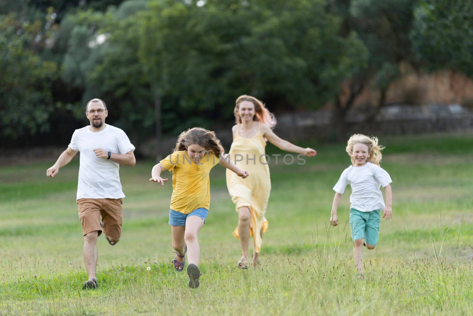 Family enjoying a sunny day running together in a field