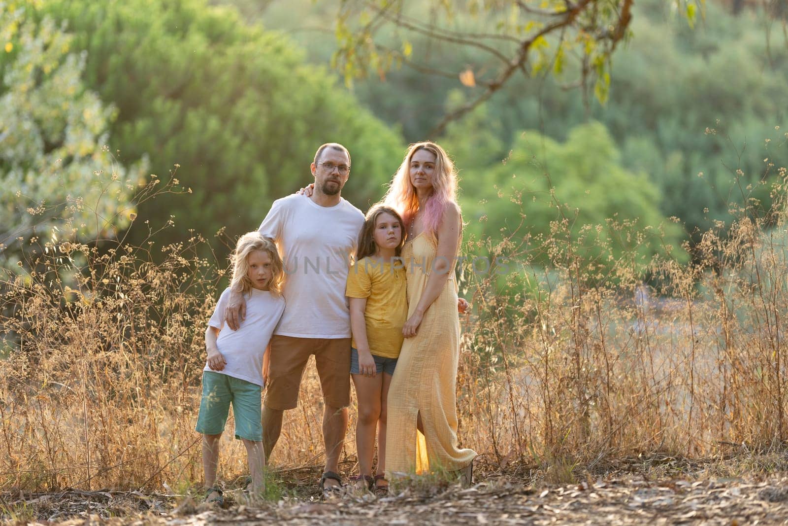 Family with two daughters posing together in a nature reserve