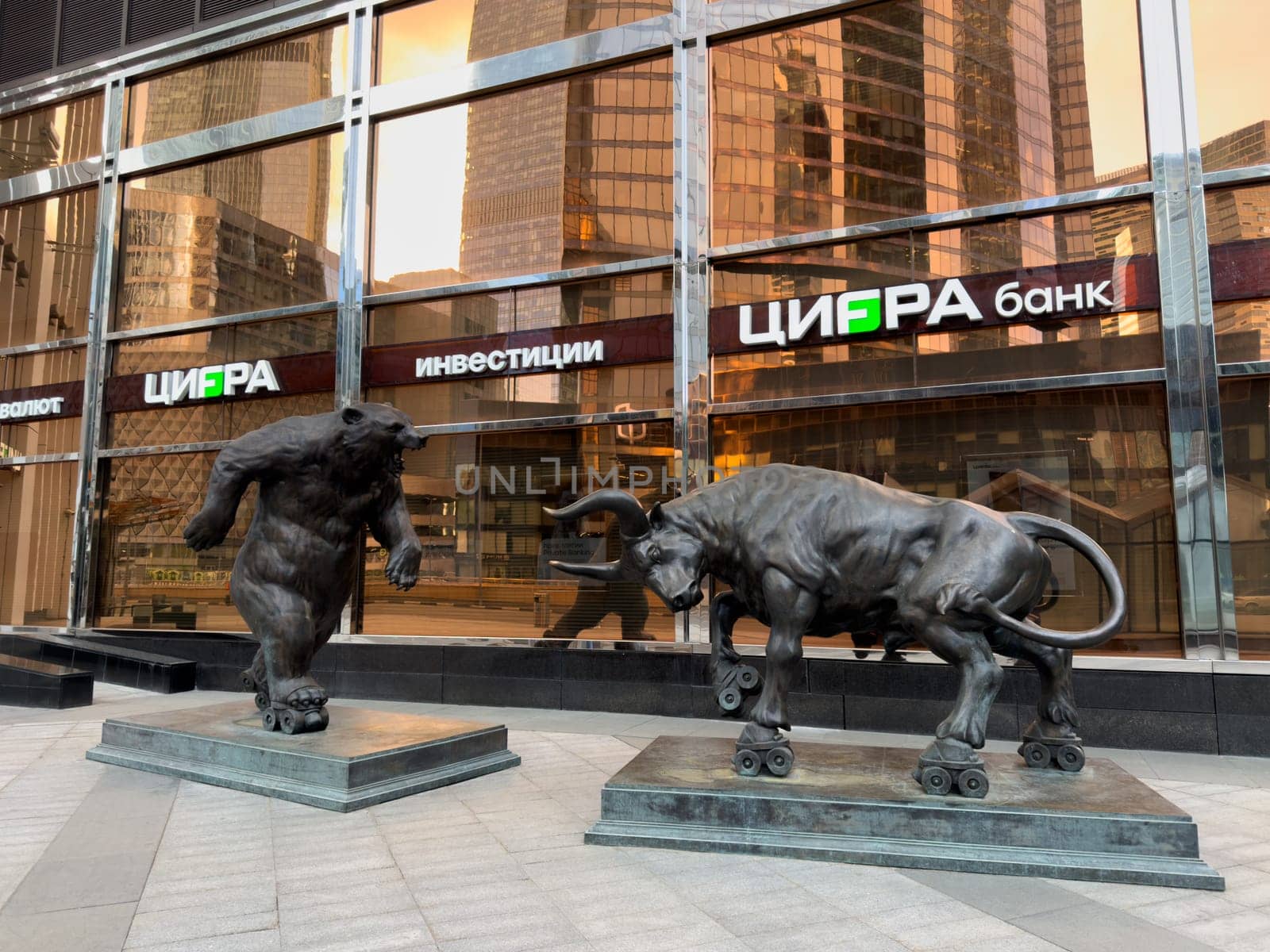 Moscow, Russia, April 26, 2025: Modern sculptures of bear and bull on roller skates in front of CIFRA Bank in Moscow City highlight the dynamic nature of financial markets and investment behavior