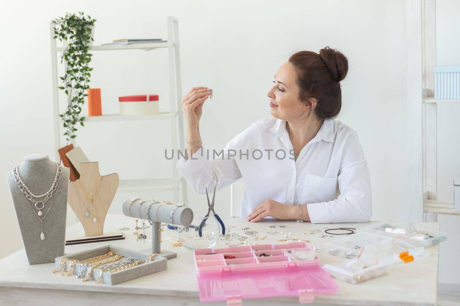 Professional jewelry designer making handmade jewelry in studio workshop. Fashion, creativity and handmade concept.