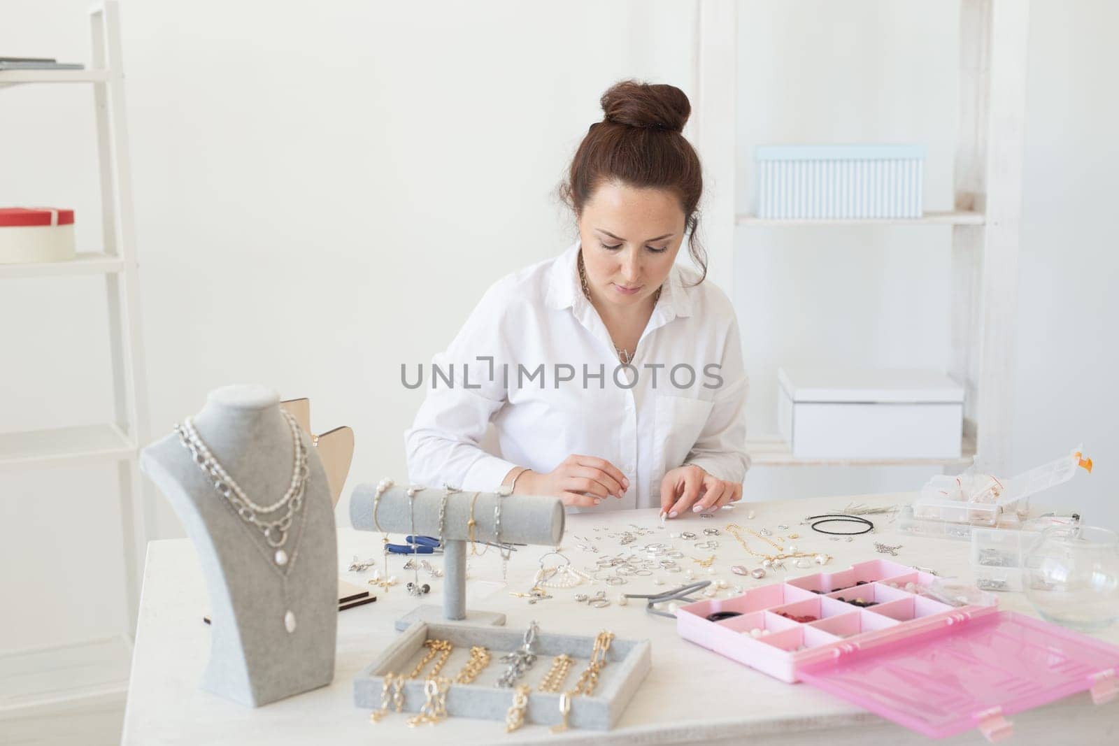 Professional jewelry designer making handmade jewelry in studio workshop. Fashion, creativity and handmade concept.
