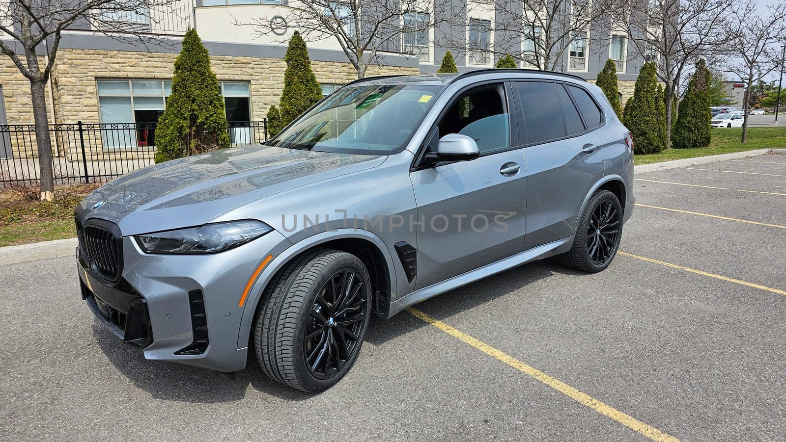 Ottawa, ON Canada - 04.22.2023: Sleek Gray Modern BMW X5 SUV Parked on Asphalt with Building Backdrop. Automotive Excellence