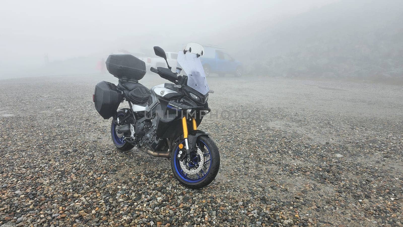 Sargents Purchase, NH USA - 08.22.2024: Motorcycle Adventure on a Foggy Day at Mountain Washington. Touring Bike Parked on a Gravel Road. Scenic Landscape