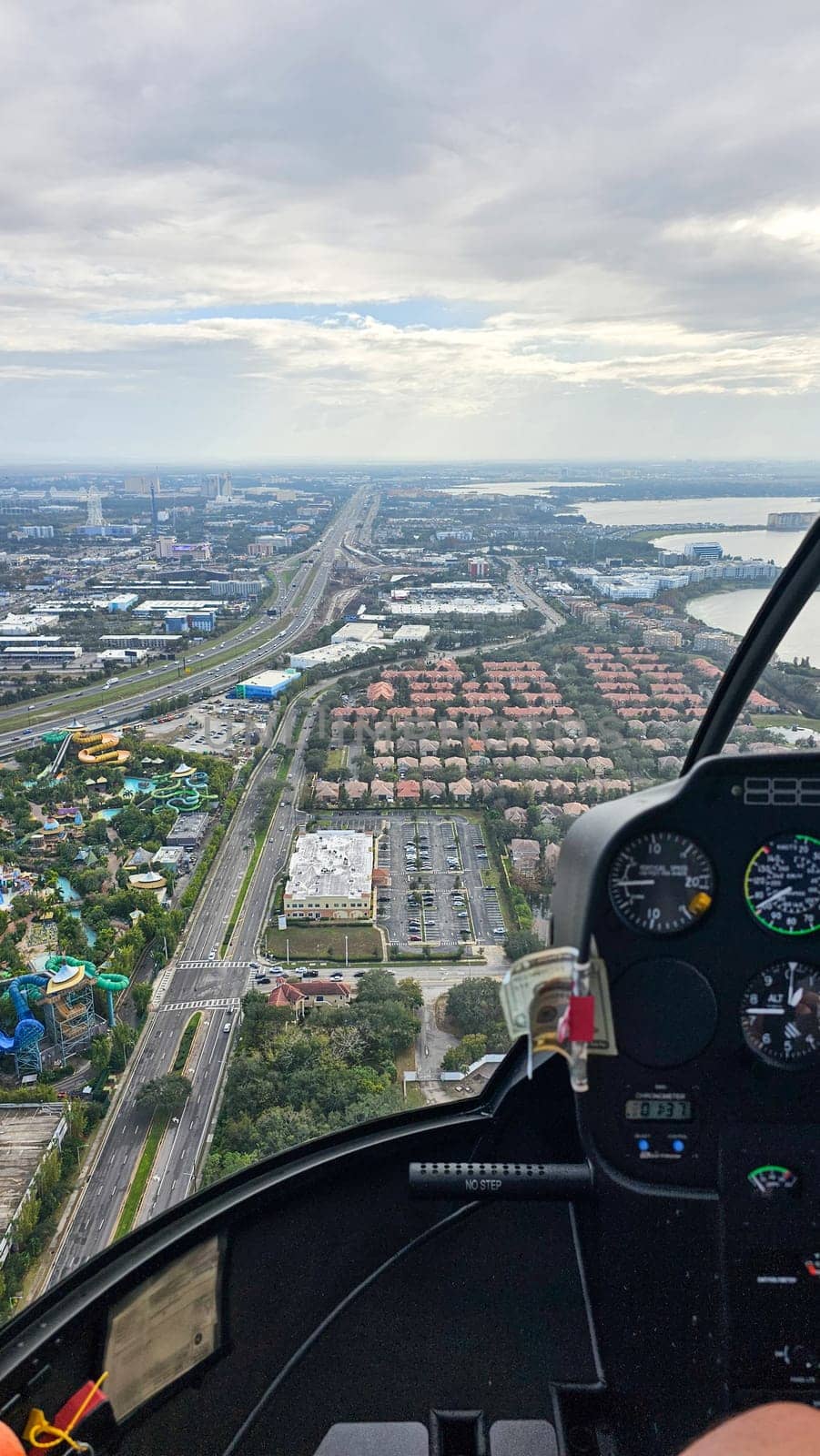 Orlando, FL USA - 12.31.2024: Aerial View of a Cityscape with Highways, Residential Areas, and Water Park from Helicopter.