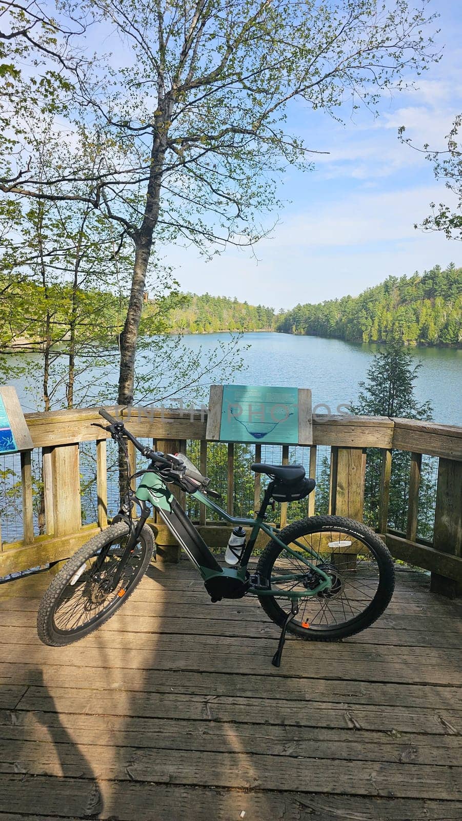 Gatineau, QC Canada - 05.13.2025: Electric Bicycle on Lakeside Deck with Scenic View, Serene Outdoor Adventure Awaits You.