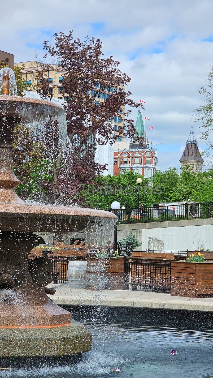 Ottawa, ON Canada - 05.14.2025: Scenic Ottawa Fountain View with Parliament Buildings in the Background on a Sunny Day.