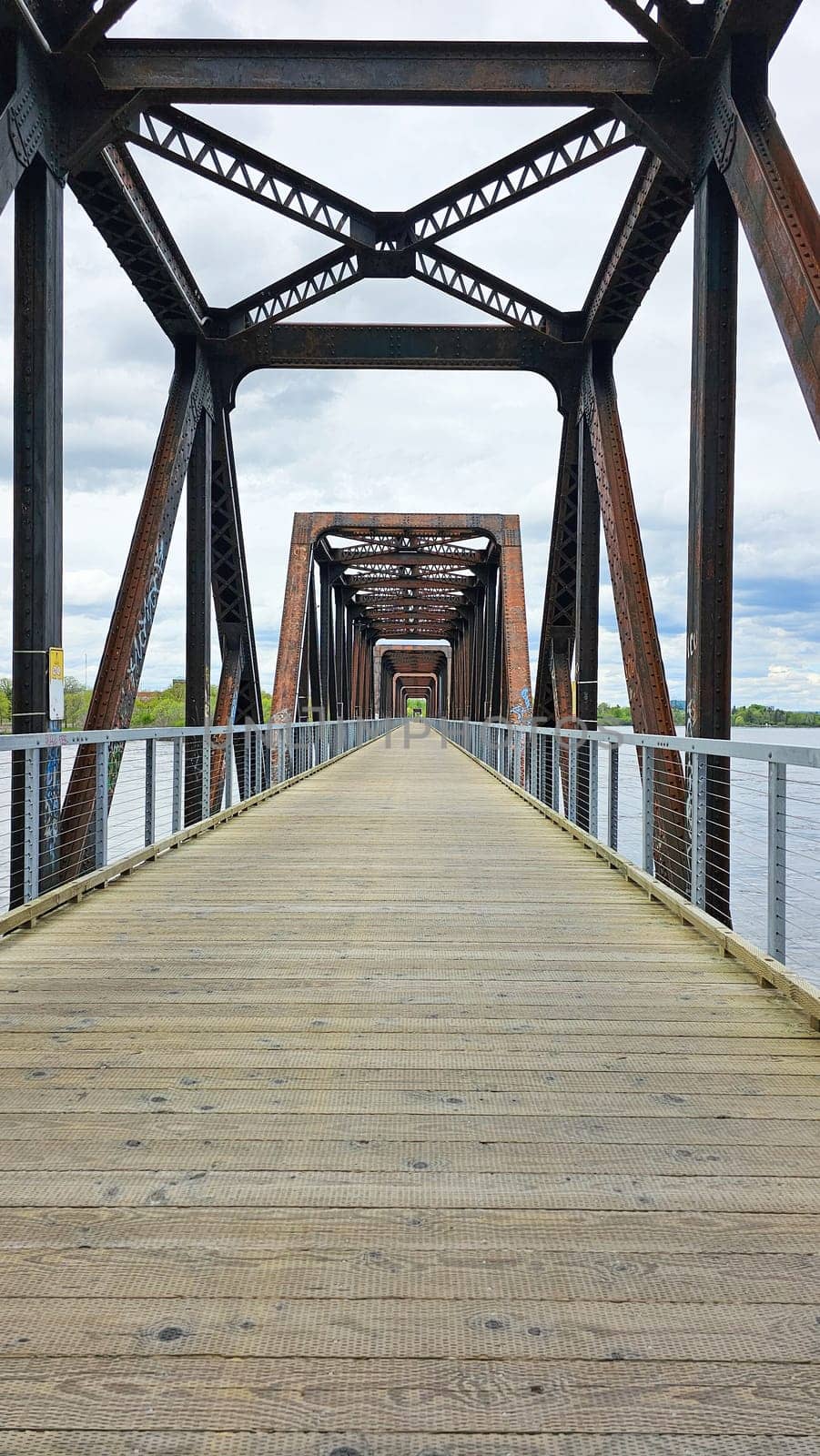 Ottawa, ON Canada - 05.14.2025: Scenic Walkway Perspective View of a Metal Truss Bridge with Wooden Path. Travel Destination