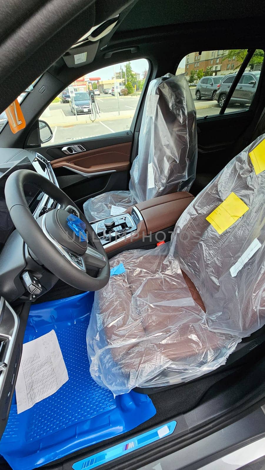 Ottawa, ON Canada - 09.12.2024: New Car Interior with Protective Covers, Modern Design, and Luxurious Brown Leather Seats.