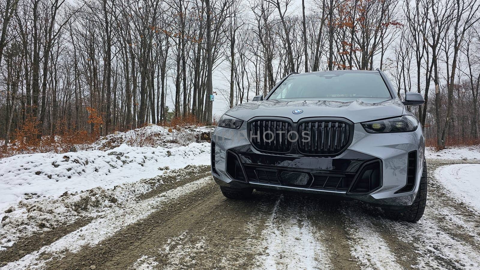 Ottawa, ON Canada - 01.12.2025: Modern vehicle on a muddy road surrounded by snow and trees during a cloudy day in nature.