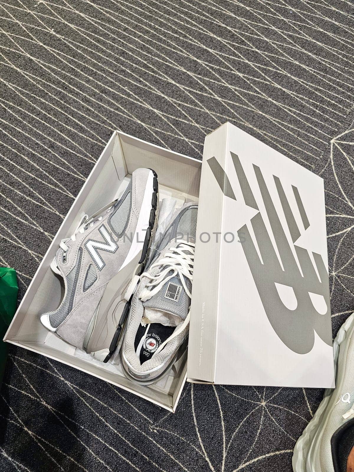 Ottawa, ON Canada - 06.12.2024: Stylish Gray Athletic Shoes in Box on Patterned Carpet for Active Lifestyle Concepts