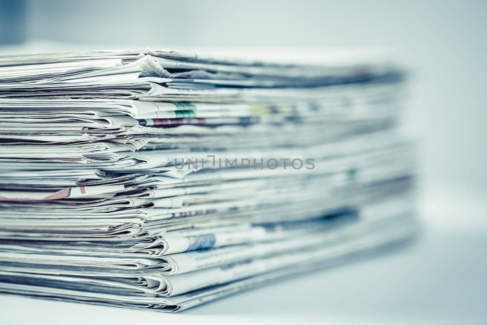Pile of newspapers on table. Folded and stacked journals.
