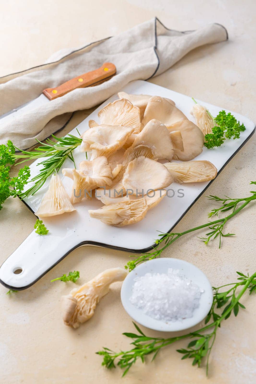 Fresh organic oyster mushrooms (Pleurotus ostreatus) on white chopping board with parsley
