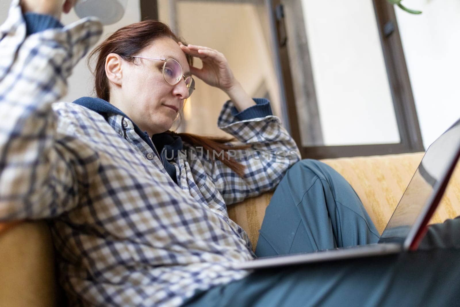 Stressed freelancer woman working from home having headache while using laptop computer