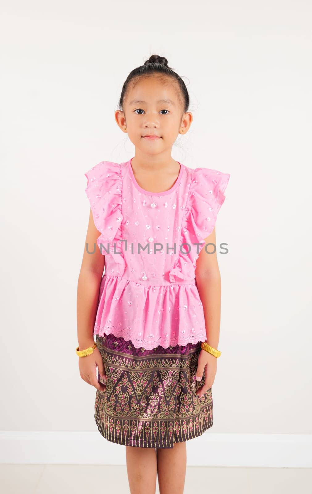 Portrait of Thailand kid girl smiling traditional Thai dress costume in studio shot isolated white background, Happy Portrait kindergarten little woman stand and looking to camera