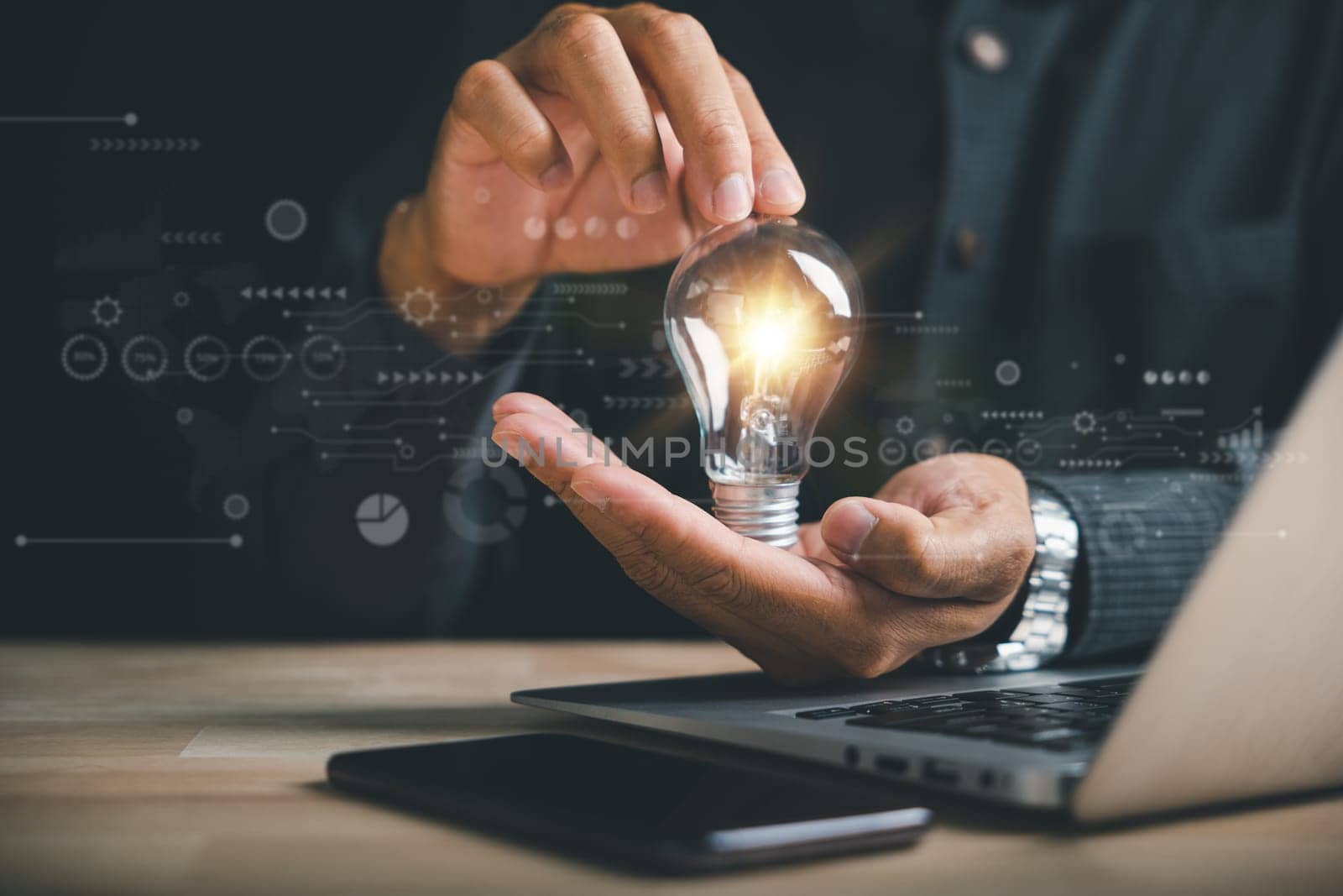 Businessman's hand holds a light bulb, representing the power of imagination. Highlights the concept of creativity, inspiration, and successful profit in global business.