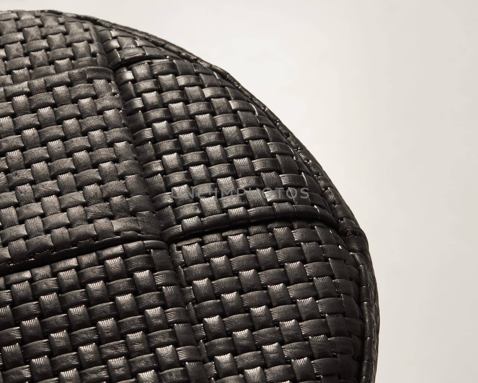 Intricate woven pattern of black leather creates a textured and stylish surface