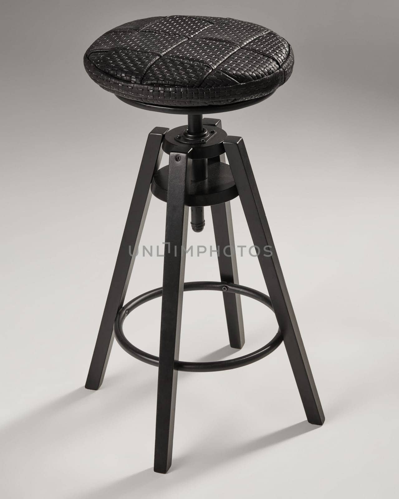 Adjustable height bar stool featuring a black woven leather seat and tripod base, ideal for modern kitchen islands