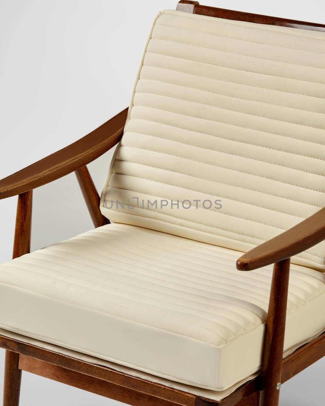 Wooden armchair with cream ribbed cushions offers a blend of comfort and style, perfect for adding a touch of elegance to any interior