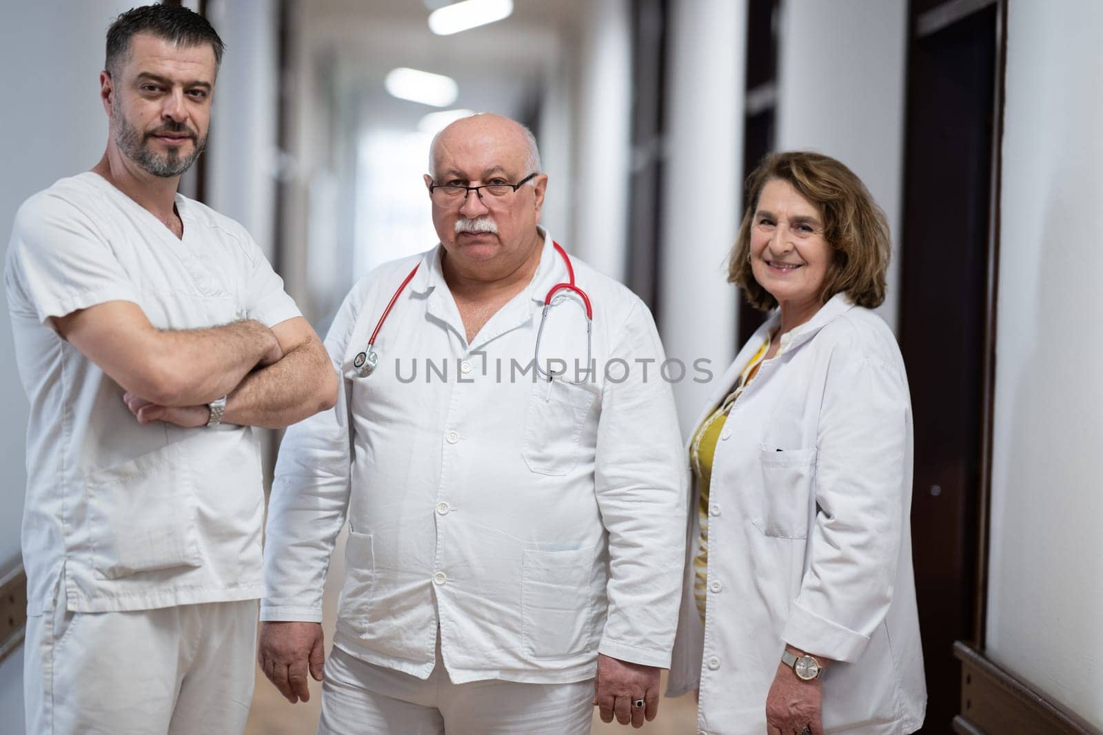 A team of experienced doctors standing in the hospital hallway, weary but dedicated after a long day of caring for patients