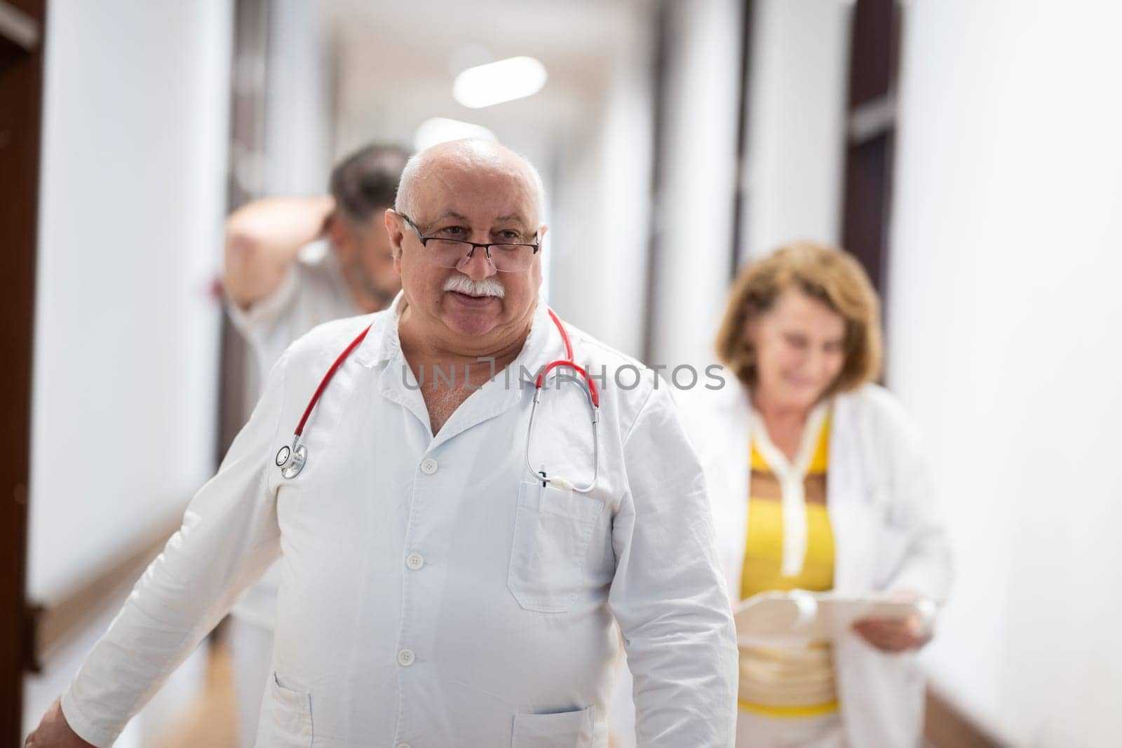 Medical personnel, including doctors and nurses, urgently respond in a busy hospital hallway, showcasing their quick action and teamwork in a critical situation