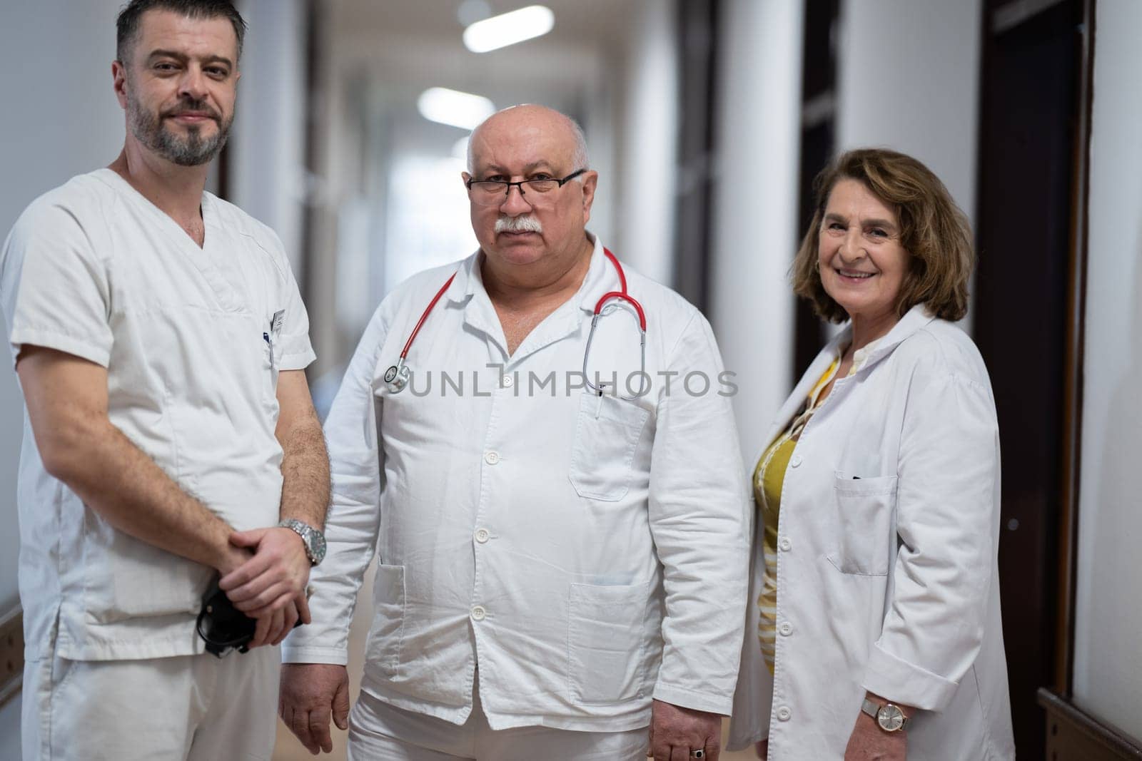 A team of experienced doctors standing in the hospital hallway, weary but dedicated after a long day of caring for patients