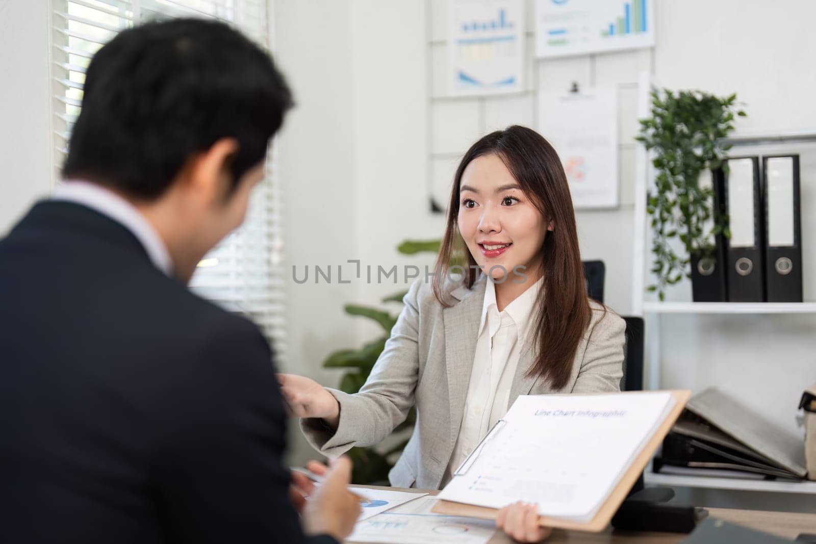A client and financial advisor share insights in a bright office, focusing on financial strategies and future planning for empowerment.