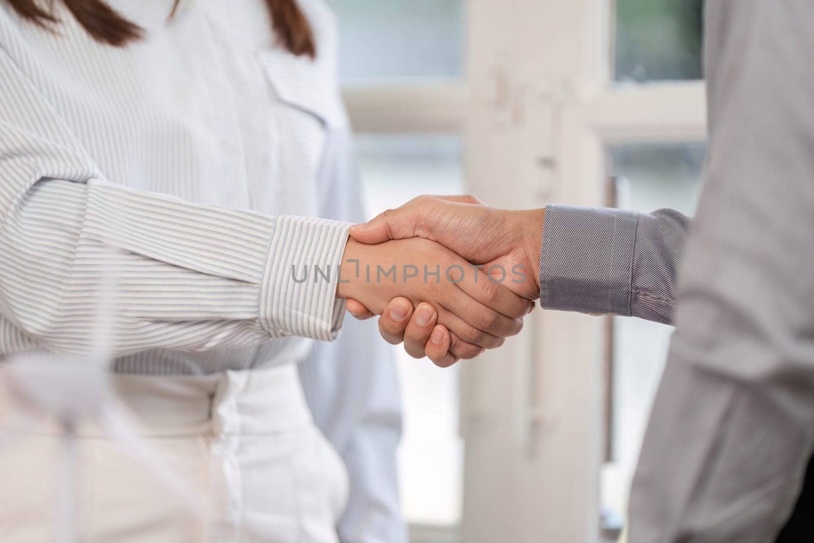 A close-up view of a handshake, representing a business agreement and mutual trust between colleagues.