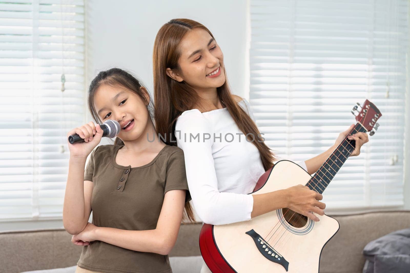 A mother and her daughter share a musical duet, creating a joyful atmosphere filled with laughter and love, celebrating their bond.
