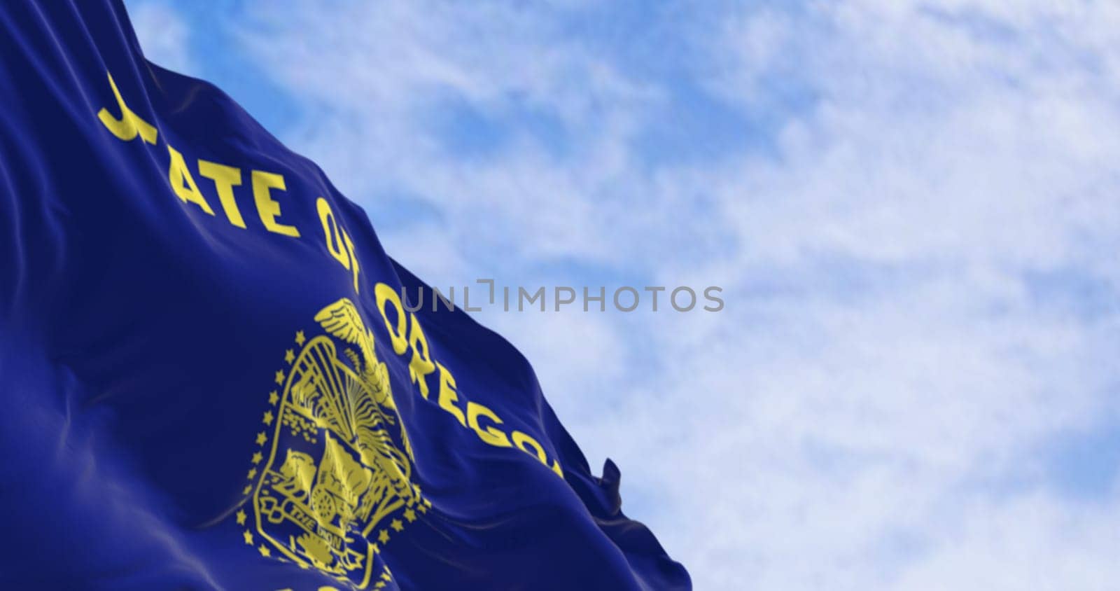 Oregon state flag waving in the wind on a clear day. The Oregon flag is two-sided with navy blue and gold colors. 3d illustration render. Fluttering fabric. Waving flag