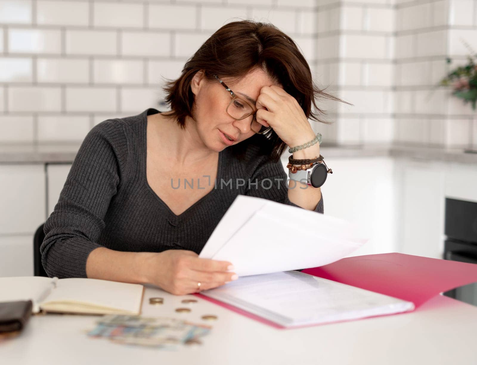 Distressed Woman Sorts Out Finances At Home Table